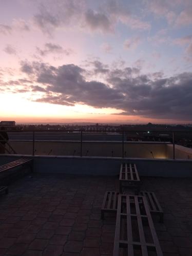 two benches on the roof of a building with a sunset at El Hogar near UN Headquarters, Gigiri in Kiambu