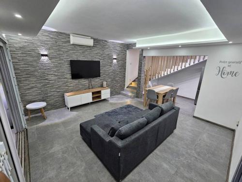 sala de estar con sofá y TV de pantalla plana en Rooftop Spa Luxury Villa, en Rivière Noire