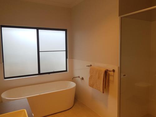 a bathroom with a bath tub and a window at The Zen Town House Pemberton in Pemberton