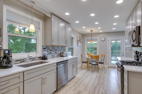 a large kitchen with white cabinets and a dining room at Waterfront Lakehouse with Private Dock and Fire Pit! in Chapin