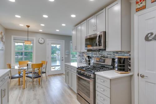 a kitchen with white cabinets and a table with chairs at Waterfront Lakehouse with Private Dock and Fire Pit! in Chapin