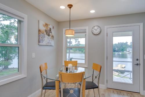 a dining room with a table and chairs and a clock at Waterfront Lakehouse with Private Dock and Fire Pit! in Chapin