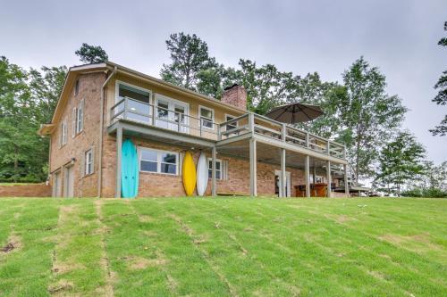 a house with a large lawn in front of it at Waterfront Lakehouse with Private Dock and Fire Pit! in Chapin