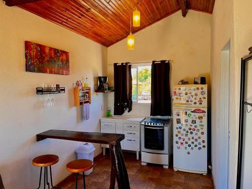 a kitchen with a refrigerator and a table in it at Chalé Uyuni in Alto Paraíso de Goiás