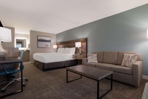 a hotel room with a bed and a couch at Best Western Flagship Inn in Moss Point