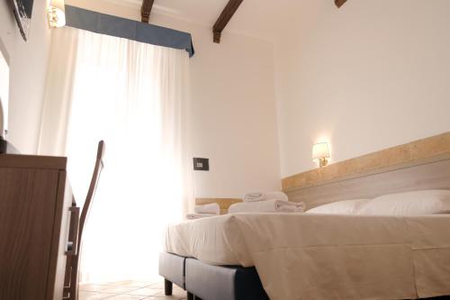 a bedroom with two beds and a large window at Hotel Alex Square in Rome