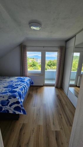 a bedroom with a bed and two large windows at Villa Amellina in Ilidža