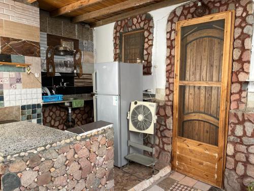 a kitchen with a refrigerator and a wooden door at Haven Hideaway - The Summer Moon House in Dahab