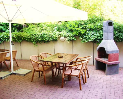 a wooden table and chairs with a wood stove at Apart Hotel Sarstedter Hof in Sarstedt