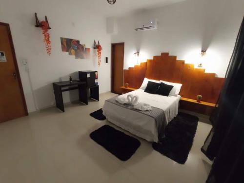 a bedroom with a bed with a large wooden headboard at Central Palace Hotel in Fortaleza