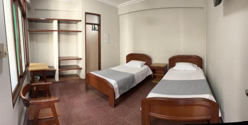 um quarto de hospital com duas camas e uma secretária em RESIDENCIAL CAÑADA em Santa Cruz de la Sierra