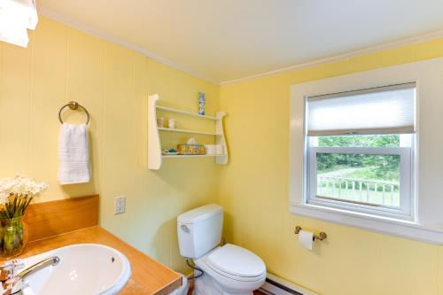 a bathroom with a toilet and a sink and a window at Pet-Friendly Maine Cottage By Northern Bay in Penobscot