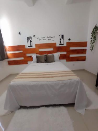 a bedroom with a large bed with a wooden headboard at Central Palace Hotel in Fortaleza