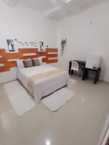 a bedroom with a large bed and a desk at Central Palace Hotel in Fortaleza