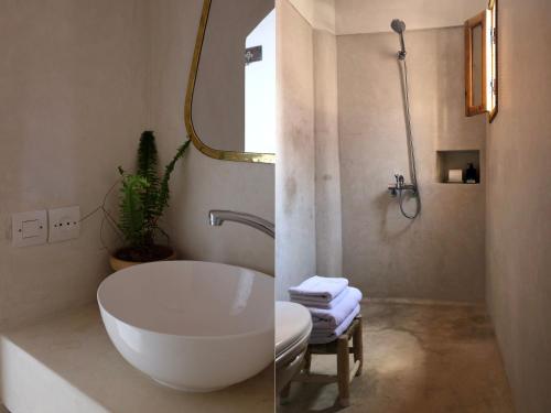 a bathroom with a large white tub and a sink at Dar Oki in Marrakesh