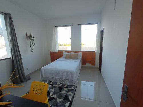 a bedroom with a bed and a yellow chair at Central Palace Hotel in Fortaleza
