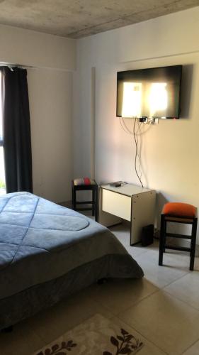 Dormitorio con cama y escritorio con luz en Belgrano suite en Salta