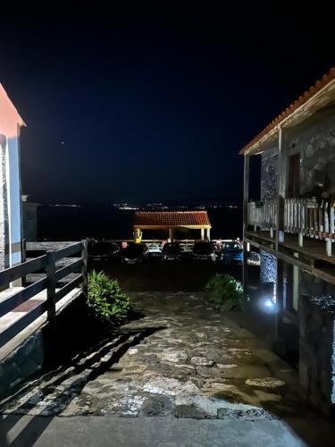 a view of a house at night with the ocean at Sara Village in São Roque do Pico