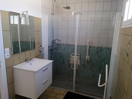 W łazience znajduje się prysznic z umywalką i szklanymi drzwiami prysznicowymi. w obiekcie Chambre parquet flottant chez l'habitant w mieście Saint-Corneille