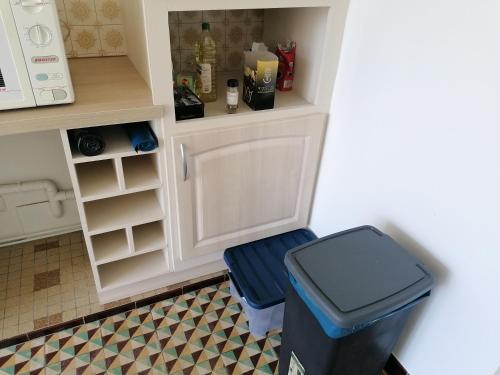 une cuisine avec une poubelle et un comptoir dans l'établissement Chambre parquet flottant chez l'habitant, à Saint-Corneille