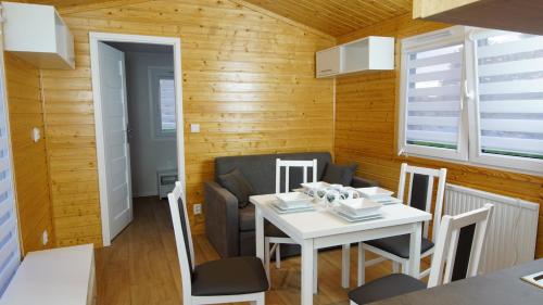 małą jadalnię z białym stołem i krzesłami w obiekcie Bungalow Camping Jacuzzi & Sauna w Solinie