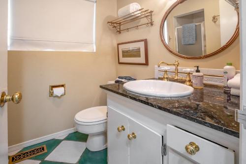 a bathroom with a sink and a toilet and a mirror at Highland Park House in Walla Walla