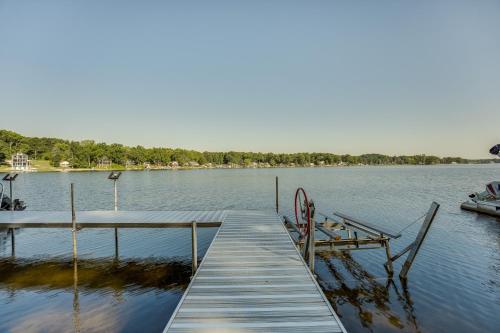 a dock on a lake with a boat in the water at Delton Oasis Retreat with Lake Views and Deck! in Delton