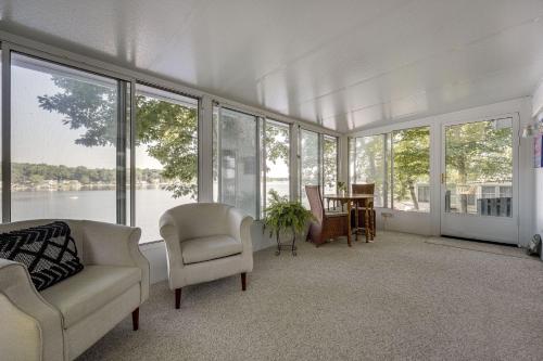 a living room with a couch and chairs and windows at Delton Oasis Retreat with Lake Views and Deck! in Delton