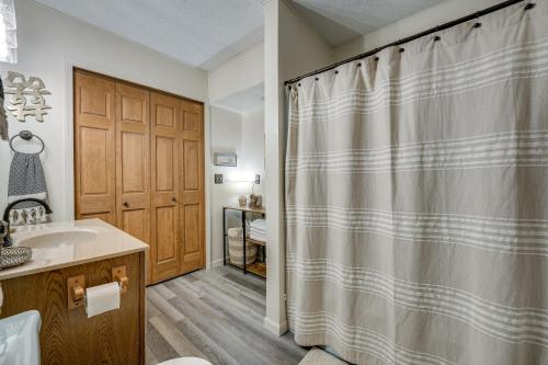 a bathroom with a shower curtain and a sink at Delton Oasis Retreat with Lake Views and Deck! in Delton