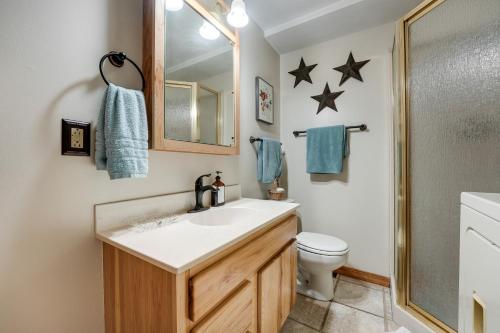 a bathroom with a sink and a toilet and a mirror at Delton Oasis Retreat with Lake Views and Deck! in Delton