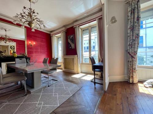 une salle à manger avec des murs rouges, une table et des chaises dans l'établissement Le Balcon de Gambetta ※, à Carcassonne
