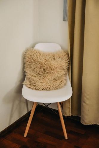 a white chair with a faux fur pillow on it at Department Pancho Olivar in Mendoza