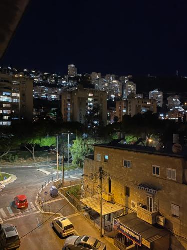 a city at night with cars parked in a parking lot at Estrela Mares Haifa in Haifa