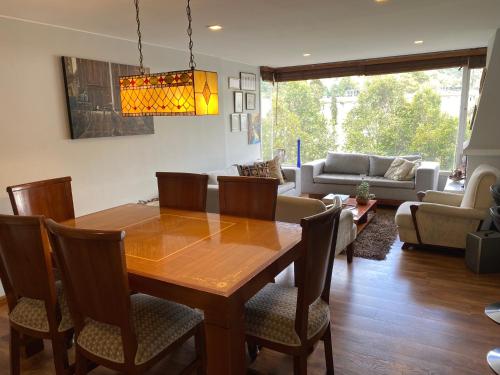 ein Esszimmer mit einem Holztisch und Stühlen in der Unterkunft Habitación 2 en sector exclusivo Usaquen in Bogotá