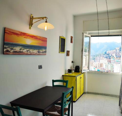 uma sala de jantar com uma mesa e um armário amarelo e uma janela em Donny Dude Panorama em Gênova