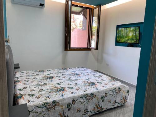 ein Schlafzimmer mit einem Bett in einem Zimmer mit einem Fenster in der Unterkunft Suite GuestHouse a pochi passi dal mare in Sassari