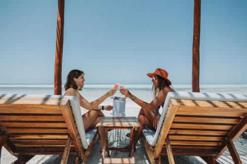 斯島的住宿－奧爾沃克斯島拉斯努布斯度假酒店，两名妇女坐在海滩上的桌子上
