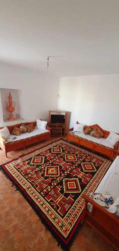 una camera con tre letti e un tappeto sul pavimento di La cascade a Houmt Souk