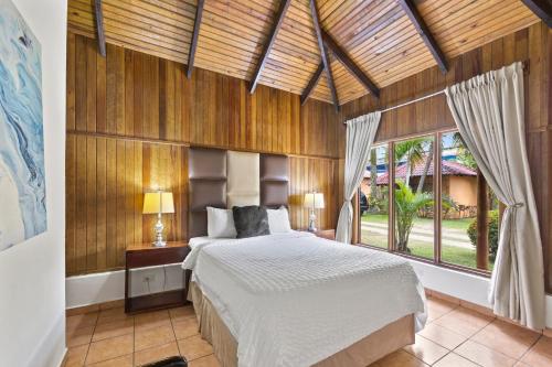 a bedroom with a bed and a large window at H4 LAS CABAÑAS in Corozal