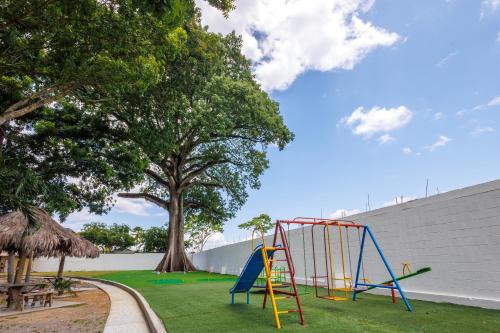 a playground with a slide in a park at H4 LAS CABAÑAS in Corozal