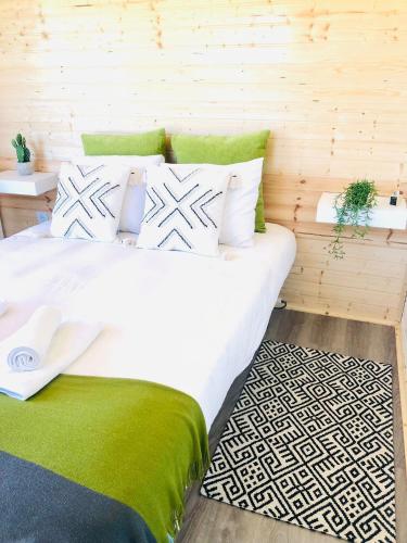 1 dormitorio con 1 cama blanca grande con detalles verdes en Varzea Nature, en Torres Vedras