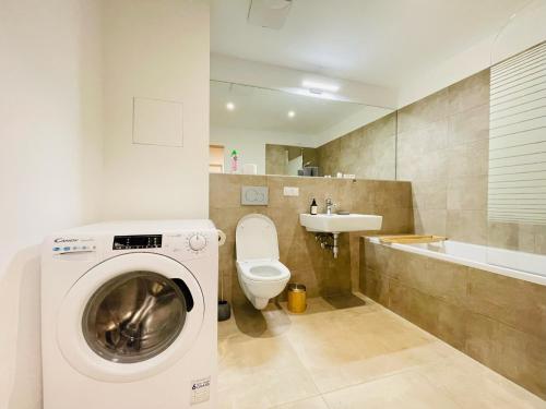 ein Badezimmer mit einer Waschmaschine und einem Waschbecken in der Unterkunft Vienna Style Apartment in Wien
