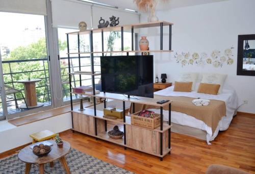 1 dormitorio con 1 cama y TV en un estante en Huidobro 1691 by depptö en Buenos Aires
