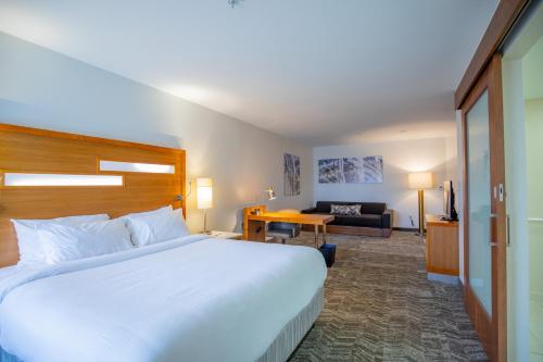 a hotel room with a large bed and a living room at SpringHill Suites by Marriott Baton Rouge Gonzales in Gonzales