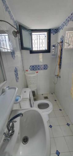 a small bathroom with a toilet and a sink at La cascade in Houmt Souk