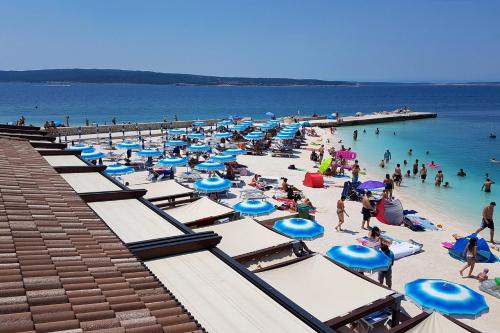 a beach filled with lots of blue and white umbrellas at Rooms with a parking space Selce, Crikvenica - 11133 in Selce
