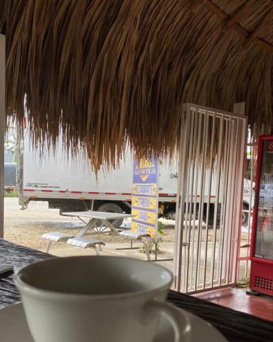 una taza de café en una mesa con techo de paja en HOTEL SAN NICOLÁS, en Cereté