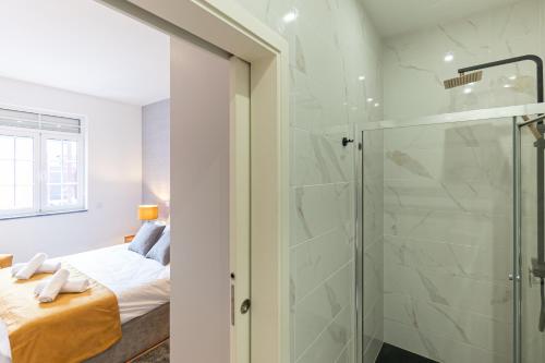 a bathroom with a glass shower and a bed at Best House Center - with Garage in Porto