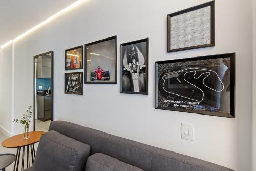 a living room with a couch and pictures on the wall at Magníficos Ap Luxo - 43mts e 63mts, 1 ou 2 Qtos in São Paulo