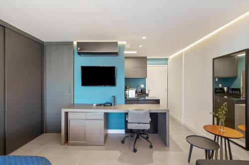 a kitchen with a desk with a tv on the wall at Magníficos Ap Luxo - 43mts e 63mts, 1 ou 2 Qtos in São Paulo